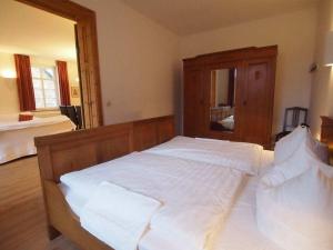 un grande letto bianco in una camera da letto con specchio di Holiday apartment with 2 bedrooms a Rattelvitz Altre 16 foto