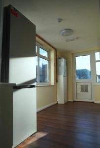 an empty room with a refrigerator and windows at SS Sunrise & Silk in Bersted