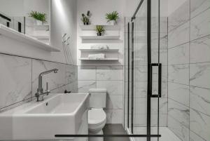 een badkamer met een toilet, een wastafel en een douche bij District 202 Loft in Québec