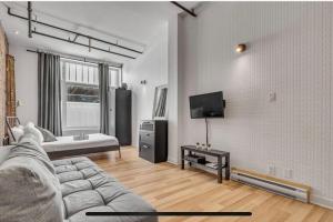 een woonkamer met een bank en een flatscreen-tv bij District 202 Loft in Québec