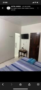 a picture of a bedroom with a bed and a table at Hotel Maria in Marabá