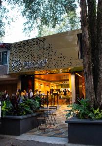 a restaurant with people sitting at tables in front of it at Habitat Ochentayuno in Medellín
