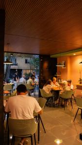 a group of people sitting at tables in a restaurant at Habitat Ochentayuno in Medellín