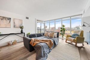 a living room with a couch and some windows at Spacious Downtown Condo - Walk to CN Tower & More in Toronto +41 photos