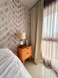 a bedroom with a bed and a lamp and a window at City Paz in Villa Carlos Paz +18 photos