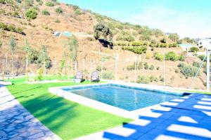 a swimming pool in a yard with a hill at Casa Billota in Torrox