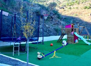 an outdoor play area with a playground with a slide at Casa Billota in Torrox