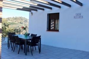 a dining room with a table and chairs on a patio at Casa Billota in Torrox