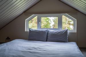 a bed with two pillows in front of a window at Ciemzeres 2 in Engure