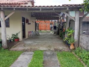 a patio outside of a house with a pergola at Casa Amarela in São Francisco do Sul