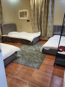 a room with two beds and a rug at المسكن الزاهي الامير فواز in Jeddah