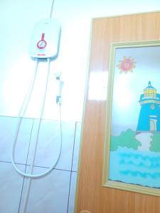 a shower in a bathroom with a picture of a lighthouse at Calitang Pearl Cottage in Nacpan