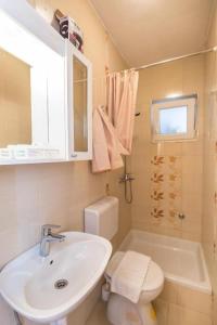 a white bathroom with a sink and a toilet at Apartments and rooms by the sea Tucepi, Makarska - 24679 in Tučepi