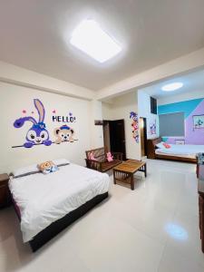 Un dormitorio con una cama con un mural de Hello Kitty en la pared. en 夏之旅民宿, en Hsien-wei