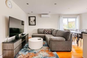 a living room with a couch and a flat screen tv at Voltaire 2 Appartement 4,5 , 2ch Laval, Canada meublé in Laval