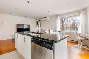 a kitchen with a sink and a dishwasher at Voltaire 2 Appartement 4,5 , 2ch Laval, Canada meublé in Laval