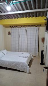 Habitación Privada في كويمبايا: غرفة نوم مع سرير أبيض أمام نافذة