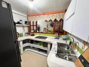 Habitación Privada في كويمبايا: مطبخ مع حوض وطاولة عمل