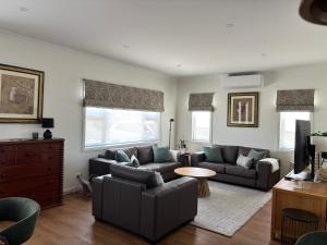 a living room with a couch and a table at Queensly Cottage in Portland