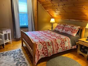 a bedroom with a bed with a wooden ceiling at Allegory Inn in Twin Mountain