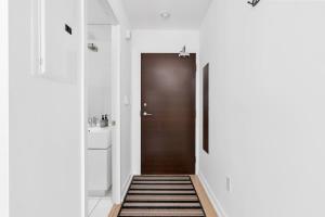 a hallway with a brown door and a sink at Sunny Downtown TO Studio - Sleeps 3 with 55 TV in Toronto