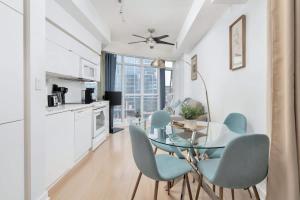 a kitchen and dining room with a glass table and chairs at Sunny Downtown TO Studio - Sleeps 3 with 55 TV in Toronto +16 photos