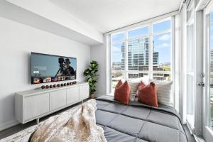 een slaapkamer met een groot raam en een televisie bij Bright 2BR Condo with by the Waterfront in Toronto