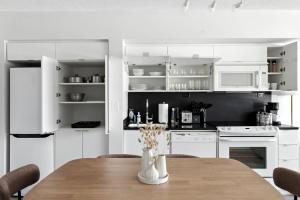 een keuken met witte kasten en een houten tafel bij Bright 2BR Condo with by the Waterfront in Toronto