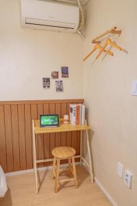 a small table with a stool and a laptop on it at Wayhome Gasan in Seoul