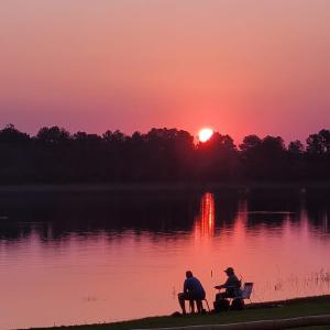 two people sitting on a bench watching the sunset at Espacio Benignia in Puerto Libertad