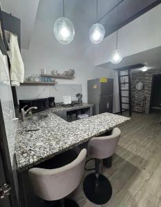 a kitchen with a granite counter top and stools at Casa Bambu in Tapantí +1 photo