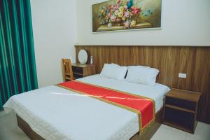 una camera da letto con un letto e un dipinto sul muro di Tam Coc Michoc Homestay a Ninh Binh