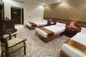 a hotel room with two beds and a chair at رتاج إن in Al Khansāk