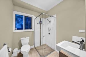 a bathroom with a shower and a toilet and a sink at Cypress Sea Breeze in Woorim +28 photos