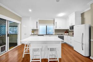 a kitchen with white appliances and a large white island at Cypress Sea Breeze in Woorim