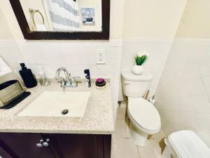 a bathroom with a toilet and a sink at Modern Luxury Executive Room with NYC Fast Access in Paterson +25 photos