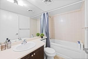 een badkamer met een wastafel, een toilet en een bad bij Spacious 3BR Condo with Patio & Free Parking in Toronto