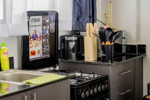 una cocina con estufa horno superior al lado de un fregadero en Cozy 1 bedroom with a pool, en Nairobi 11 fotos más