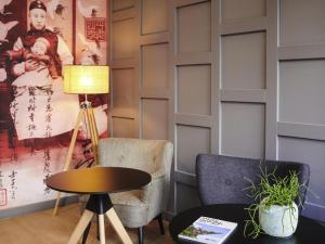 Ibis Styles Nantes Centre Place Graslin في نانت: غرفة بها كرسيين وطاولة ومصباح