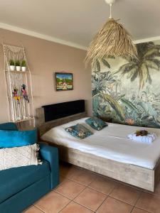 Couleur Caraïbes- 2 Appartements Communicants Vue Mer Pierre&Vacances في سانت لوسي: غرفة نوم بسرير وجدارية نخلة +57 صورة
