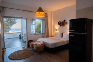 a bedroom with a bed and a view of the ocean at Divino Suites in Fira