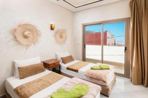 a hotel room with two beds and a window at jaws wave imsouane in Imsouane