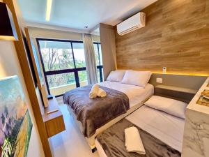 a bedroom with a large bed and a window at Maré alta flat 213 in Tamandaré +35 photos