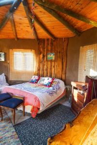 a bedroom with a bed and a wooden ceiling at Refugio de tierra con vistas en Ocoa in Viña Guzmán