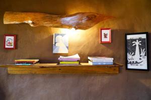 a wooden shelf with books on a wall with pictures at Refugio de tierra con vistas en Ocoa in Viña Guzmán