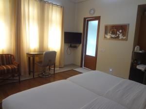 a bedroom with a bed and a desk and a chair at Astoria Hotel in Mumbai