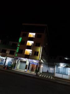 Un edificio con un cartel verde por la noche. en Hotel Lanus, en Portoviejo