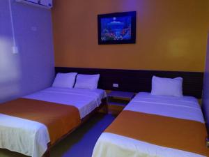 Dos camas en una habitación de hotel con en Hotel Lanus, en Portoviejo