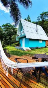 una hamaca en una terraza con una casa azul en Cabana dos Coqueiros Para-tí, en Taquara