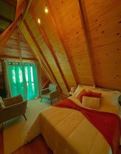 1 dormitorio con cama grande en el techo de madera en Cabana dos Coqueiros Para-tí, en Taquara